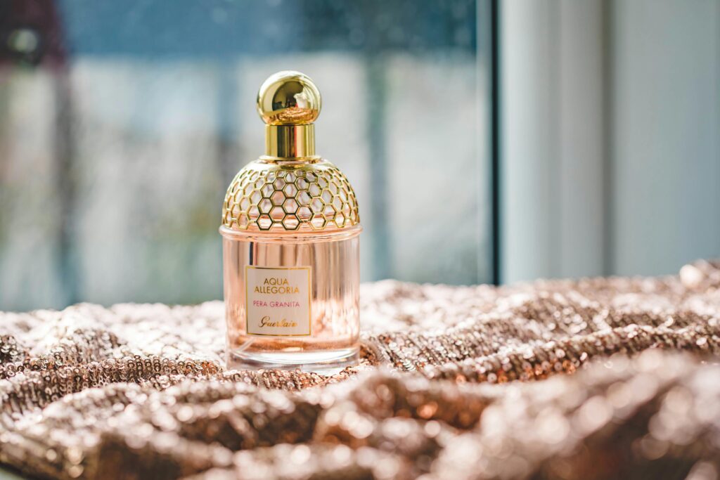 pexels-photo-1961792-1961792 Elegant Guerlain perfume bottle on a textured fabric with natural lighting, exuding luxury and fragrance.